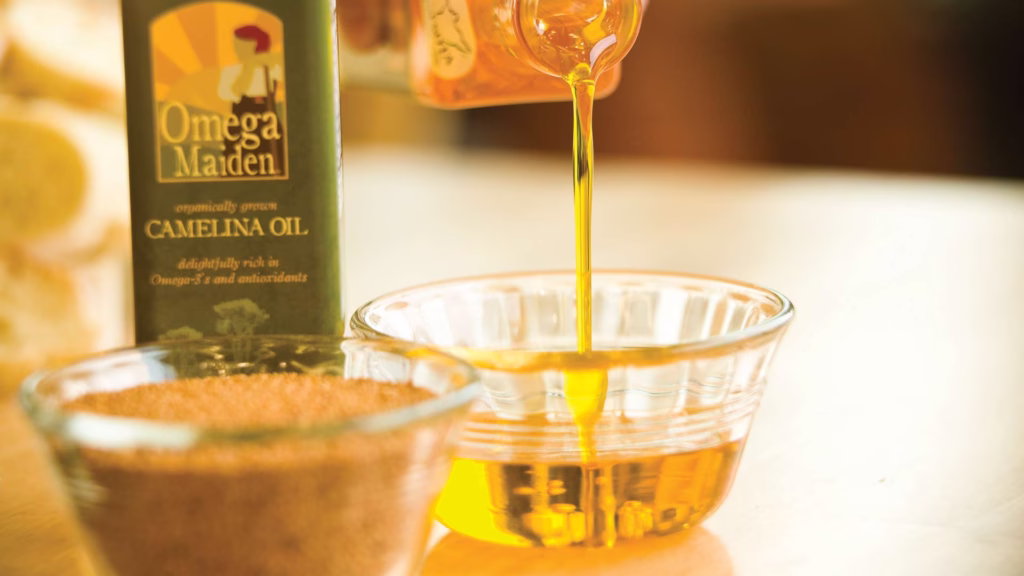 bottle of camellia oil pouring into a glass dish