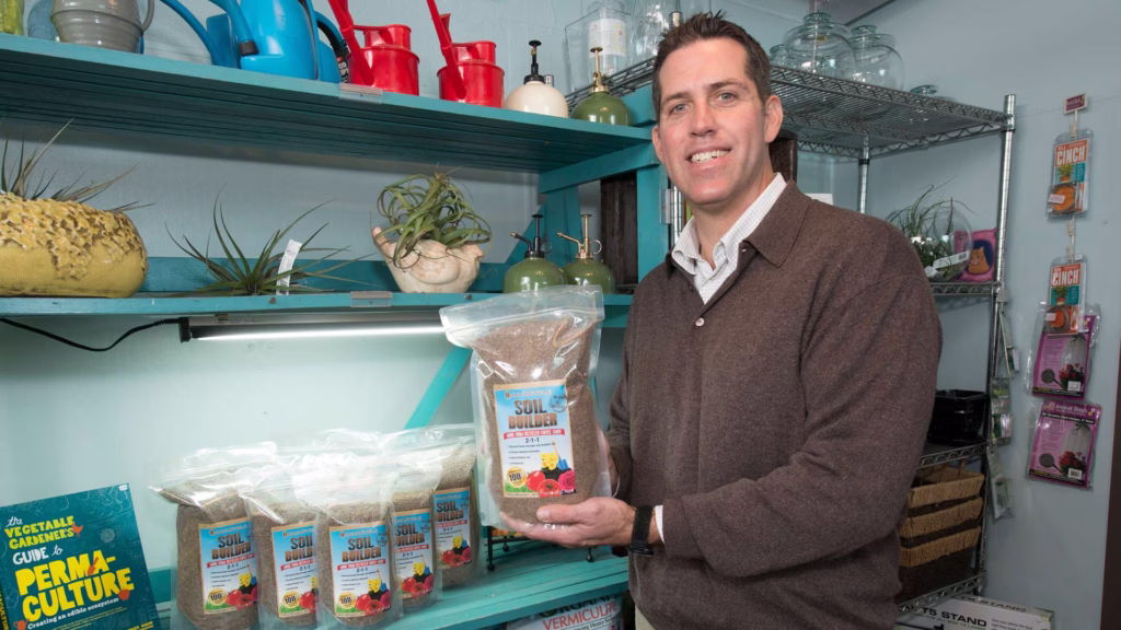 man holding bag of coffee grounds to add to soil