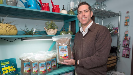 man holding bag of coffee grounds to add to soil