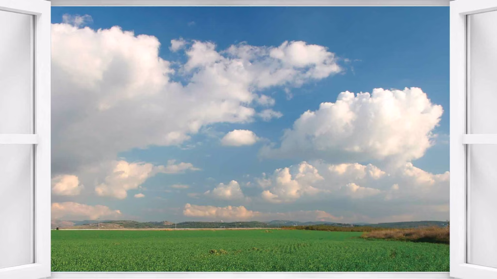 window looking out to a field with clouds