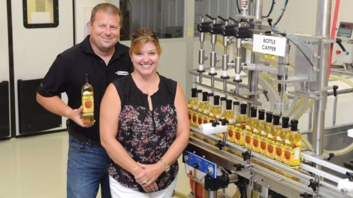 Smude couple in front of cold press oil bottle