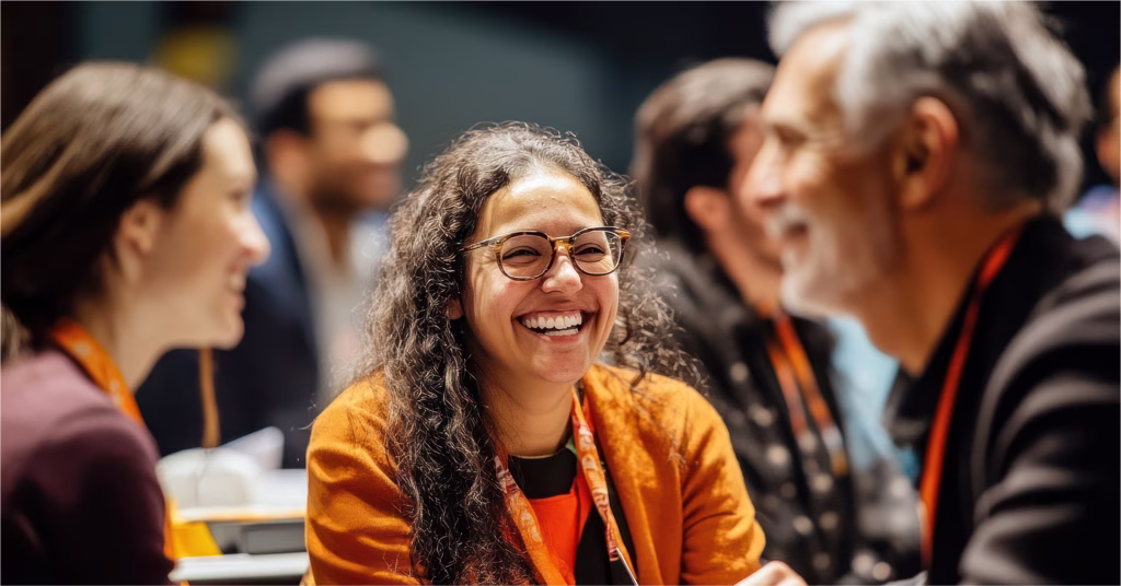 Smiling woman in glasses talking with colleagues at a conference